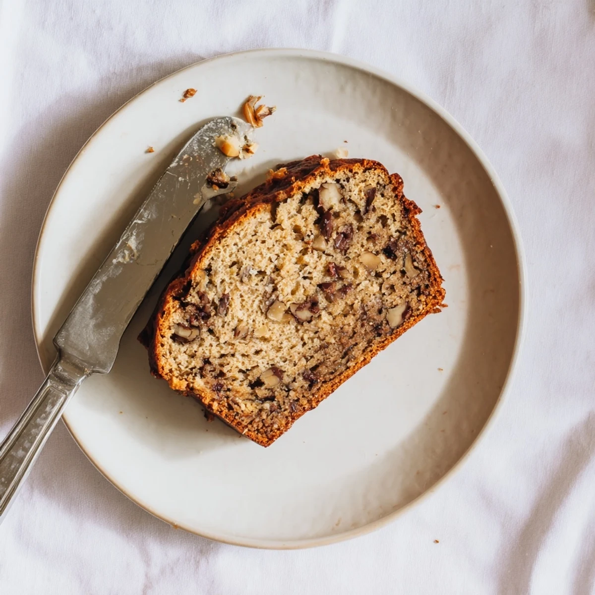 Freshly baked Banana Bread with a golden-brown crust and a moist, tender crumb, sliced and ready to serve.