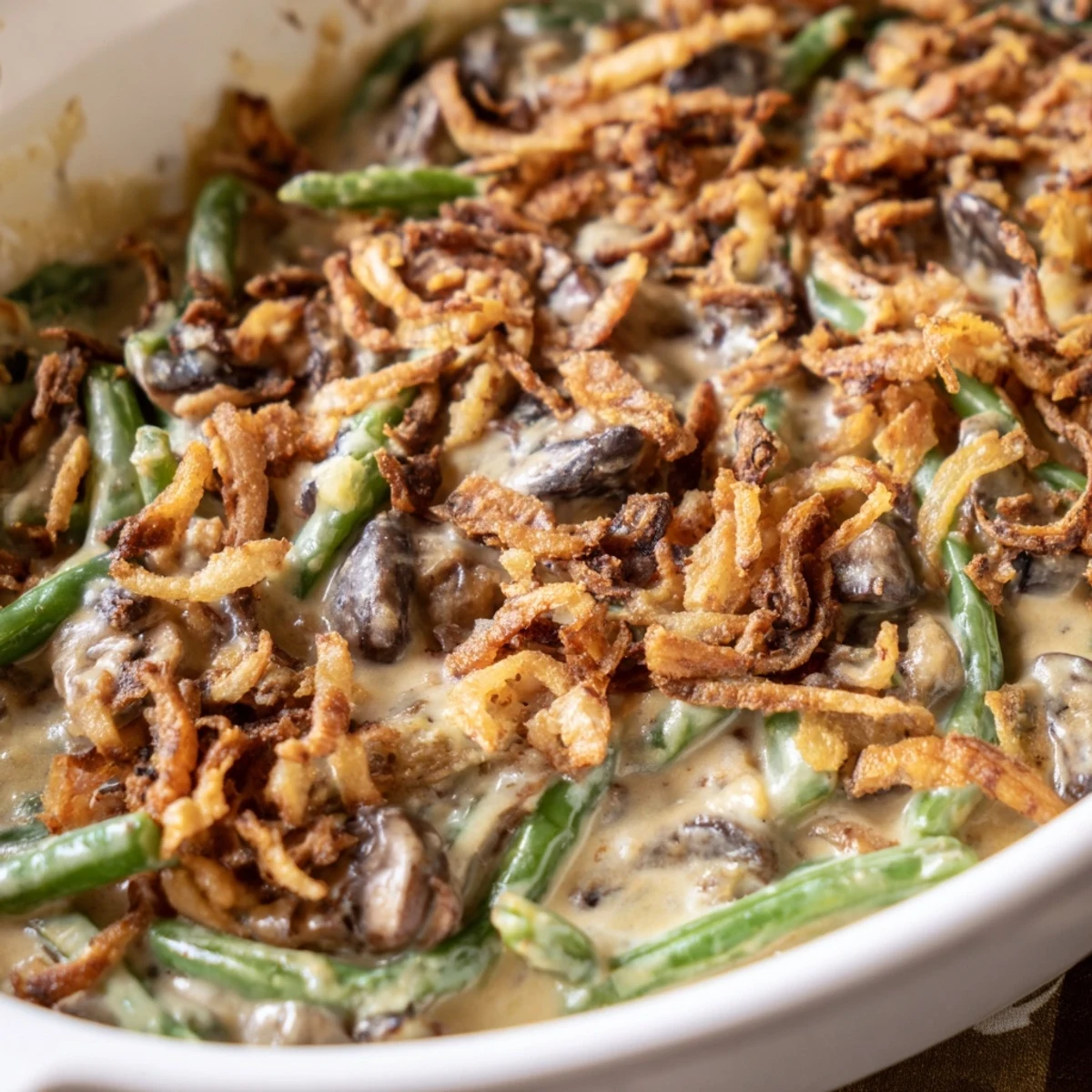 Tender green beans coated in a rich, savory sauce topped with golden crispy onions for a classic American side.