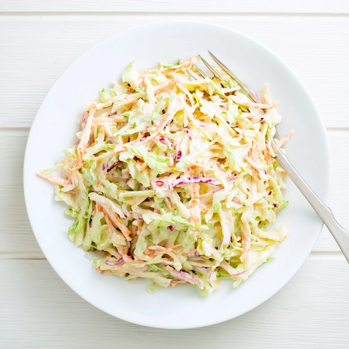 Crisp, shredded cabbage and bright carrot ribbons are tossed in a creamy, tangy dressing in this refreshing Coleslaw.