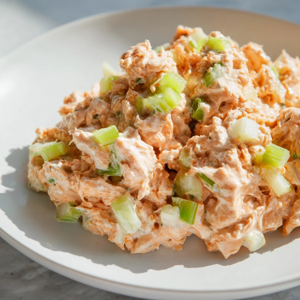 Creamy, spicy tuna salad with fresh lemon juice and scallions, perfect for a light sandwich or wrap.