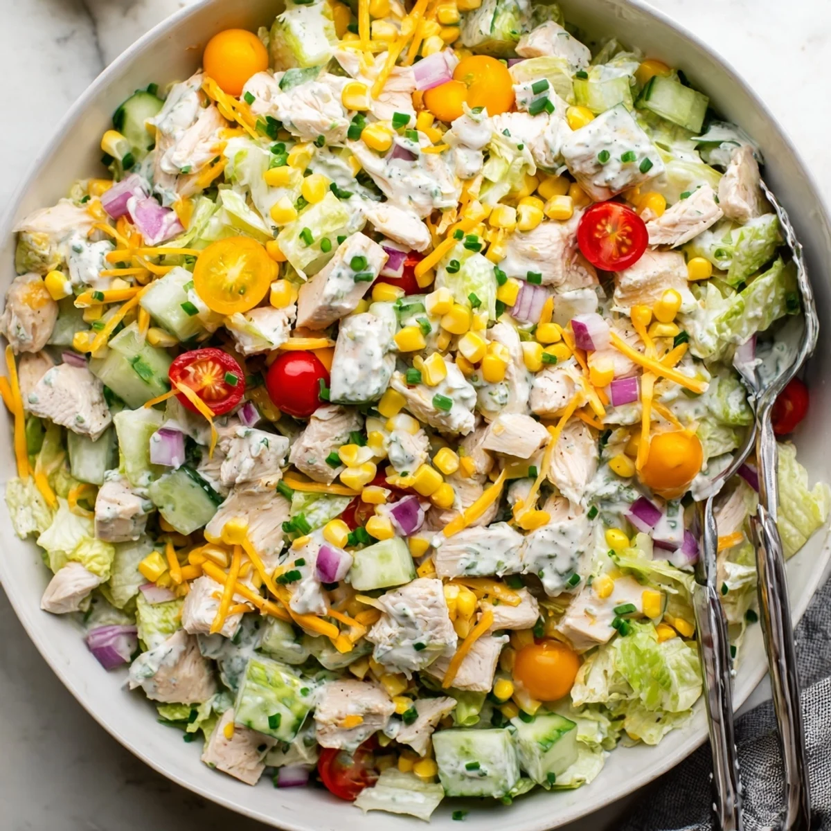 Close-up of a nutritious Ranch Chicken Chopped Salad showing tender chicken, cucumbers, and herbs on a bed of greens, ready to serve.