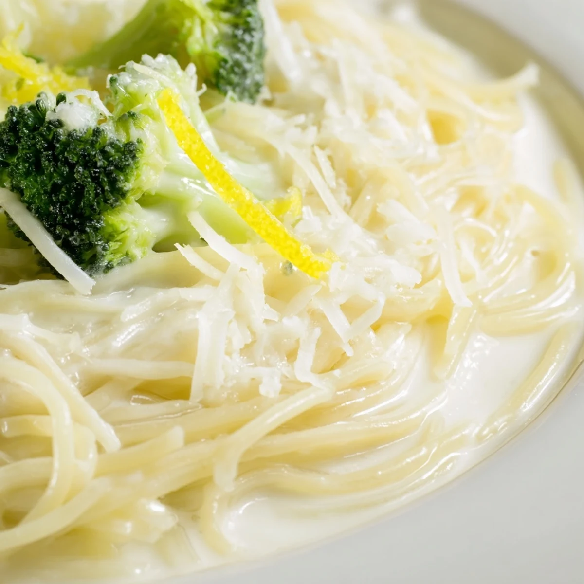 Freshly cooked One-Pot Lemon Broccoli Pasta steaming in a skillet, showcasing tender green florets and glossy noodles coated in a silky garlic sauce.  