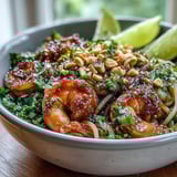 Freshly chopped cilantro and crunchy peanuts garnish this Asian Noodle Bowl served with lime wedges.