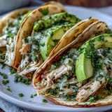Slow cooker salsa verde chicken tacos, brimming with juicy shredded chicken and fresh toppings.