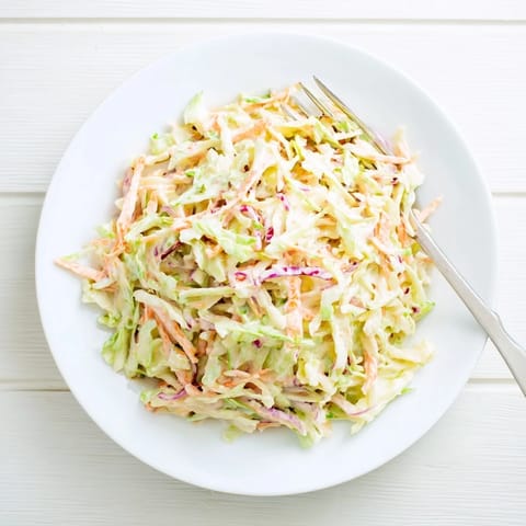 Crisp, shredded cabbage and bright carrot ribbons are tossed in a creamy, tangy dressing in this refreshing Coleslaw.