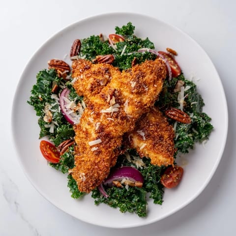 A hearty kale salad topped with crunchy panko-breaded chicken, tossed with a tangy sweet and savory maple-Dijon vinaigrette.