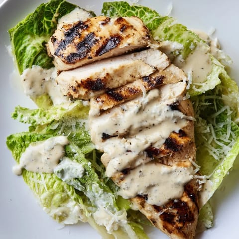 Freshly chopped lettuce and melted Parmesan cheese top the warm grilled chicken in this easy, homemade Caesar Chicken Sandwich.  