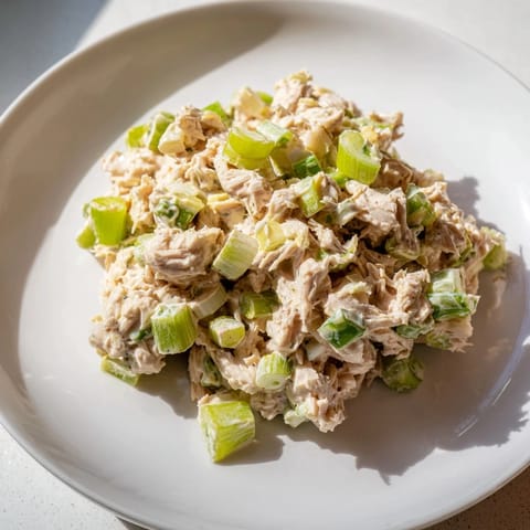 Vibrant chopped tuna salad with spicy mayo, lemon, and scallions, ready to serve in lettuce cups.