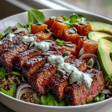 Smoky sliced steak and vibrant greens fill this bowl, showcasing caramelized butternut squash, red onion, and creamy avocado slices.