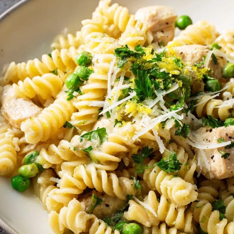 Family-style platter of Garlic Butter Chicken & Pea pasta, featuring golden chicken and bright green peas ready to serve.
