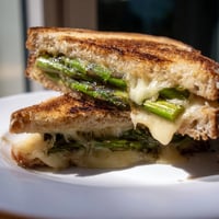 Golden-brown sourdough slices hold melted Brie and tender, charred asparagus spears in this inviting Asparagus & Brie Grilled Cheese sandwich.