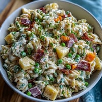Hawaiian pasta salad with ham, pineapple, and ranch in a creamy, colorful bowl, perfect for summer gatherings.  